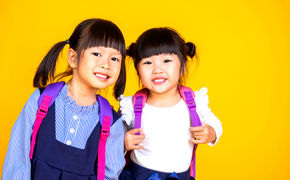 Young happy little asian toddler girls with backpack