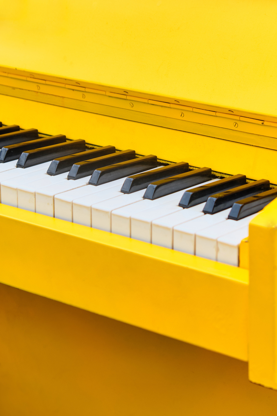 Vintage musical instrument yellow piano close up.