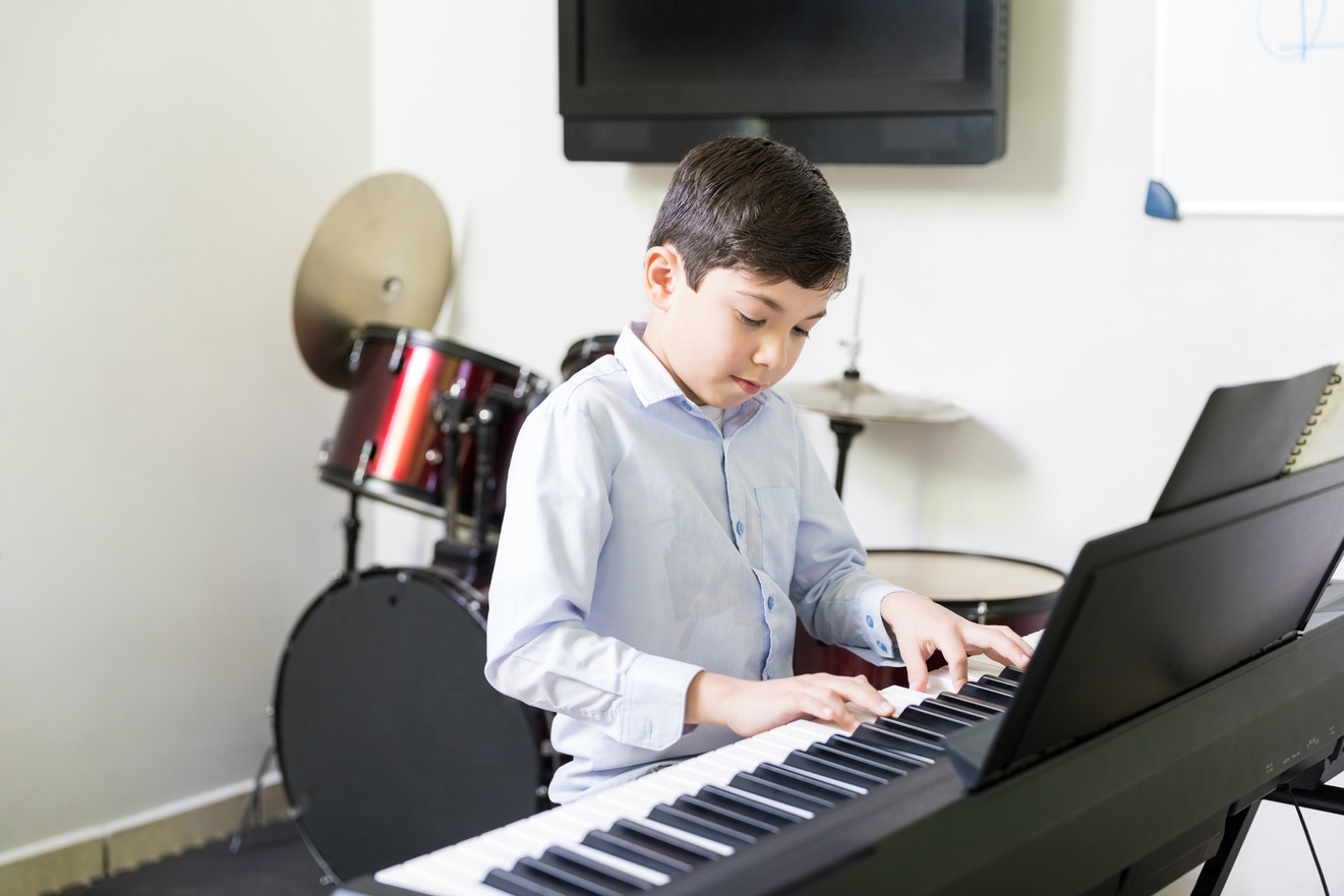 Kid Playing Electric Piano In Music School